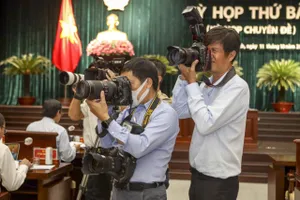 Phóng viên tác nghiệp đưa tin ở TP.HCM. Ảnh: NGUYỆT NHI