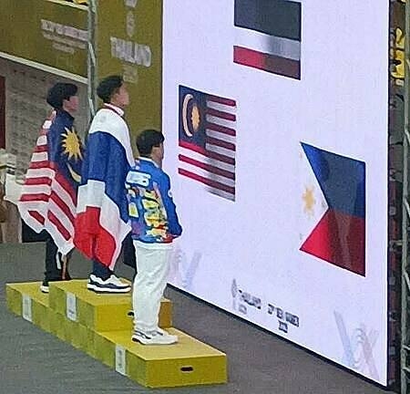 Các VĐV Thái Lan (giữa), Malaysia (trái) và Philippines chào cờ trên màn hình led. Ảnh chụp màn hình