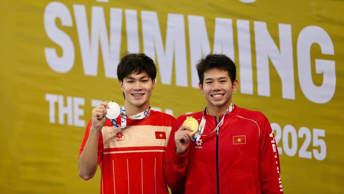 Quang Thuấn (phải) mừng tấm HC vàng, còn Hưng Nguyên mừng HC bạc. Hai kình ngư Việt Nam đổi màu huy chương so với kỳ SEA Games trước, ở nội dung 400 m hỗn hợp nam. Ảnh: Hiếu Lương