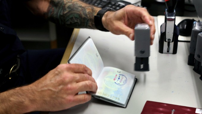 Nỗi khổ của du khách mang cuốn hộ chiếu yếu 3 Nhân viên xuất nhập cảnh đang đóng dấu vào hộ chiếu cho du khách. Ảnh: NYT