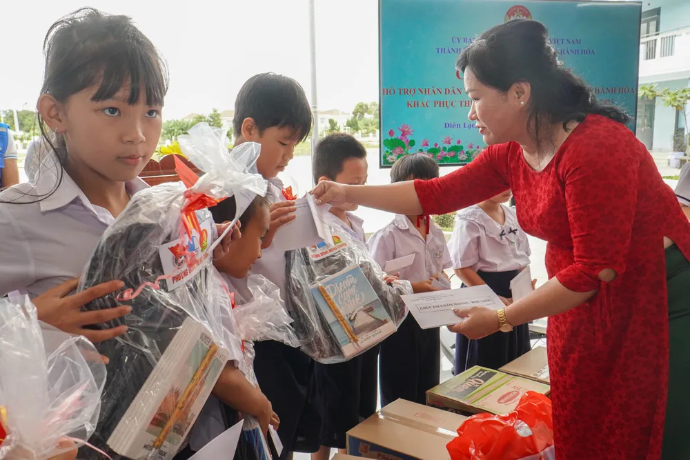 Cô Đào Ngọc Minh, Hiệu trưởng trường Tiểu học Nguyễn Thị Minh Khai TP.HCM trao học bổng, tập sách cho các em học sinh. Ảnh: XUÂN HOÁT 17.jpg