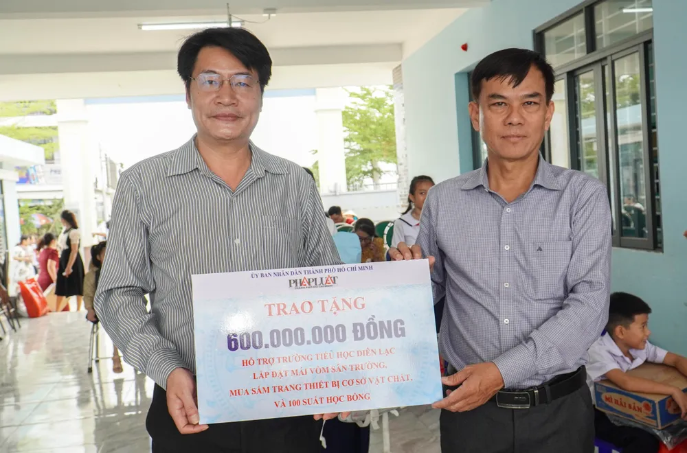 Ông Đinh Đức Thọ, Phó Tổng biên tập báo Pháp Luật TP.HCM trao 600 triệu đồng cho Trường tiểu học Diên Lạc. Ảnh: XUÂN HOÁT 12.jpg