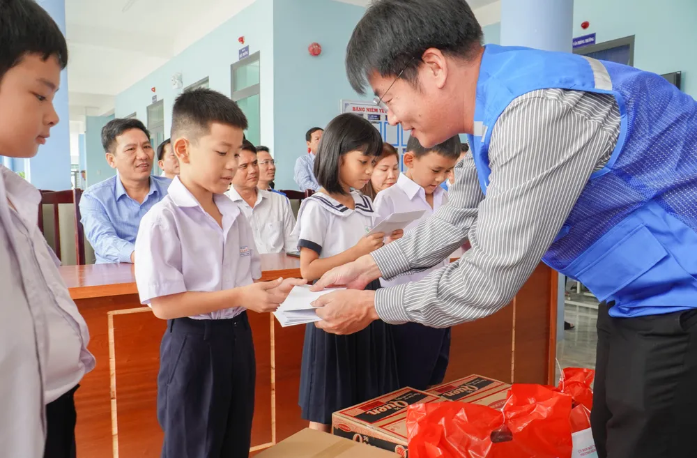 Lãnh đạo báo Pháp Luật TP.HCM trao học bổng cho các em học sinh. Ảnh: XUÂN HOÁT 16.jpg