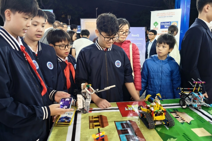 Các em học sinh trường THCS Ngô Sĩ Liên thích thú với trải nghiệm điều khiển robot. Ảnh: Trọng Đạt