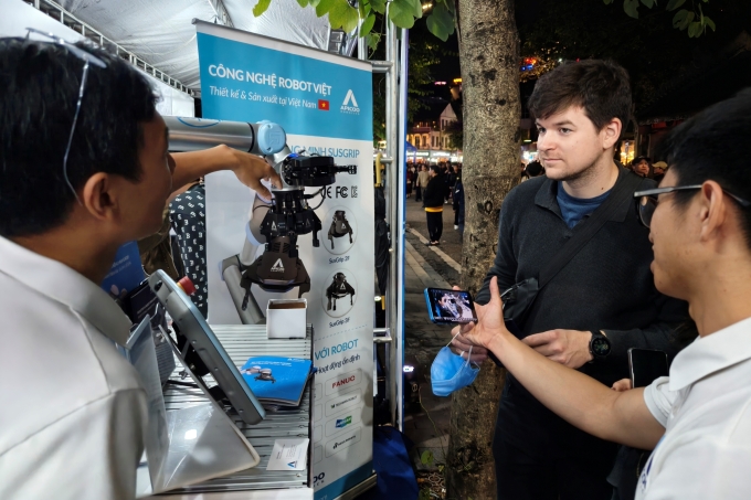 Du khách quốc tế tìm hiểu về sản phẩm tay kẹp robot Make in Viet Nam. Ảnh: Trọng Đạt