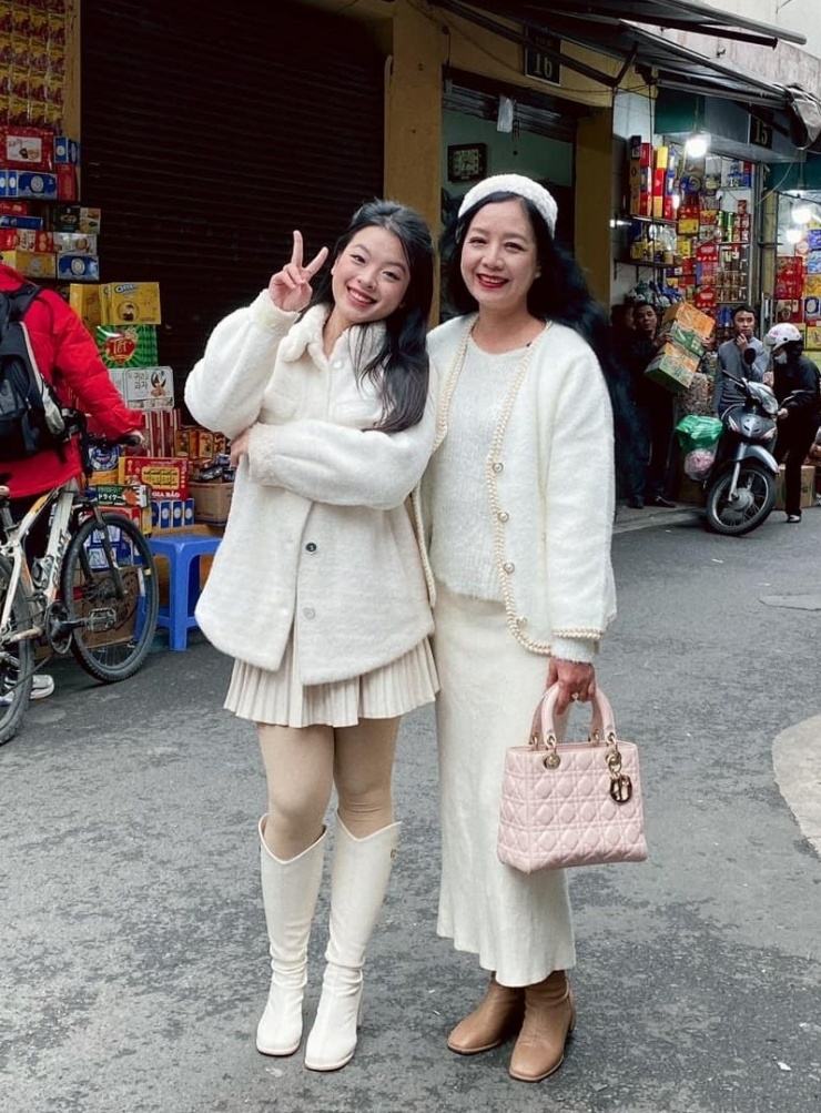 Hai mẹ con mặc đồ giống màu nhau, dạo phố mùa đông Hà Nội. Có chiều cao khiêm tốn 1,55 m, cô sắm bốt và giày cao gót kiểu dáng, màu sắc đa dạng, giúp tôn dáng.