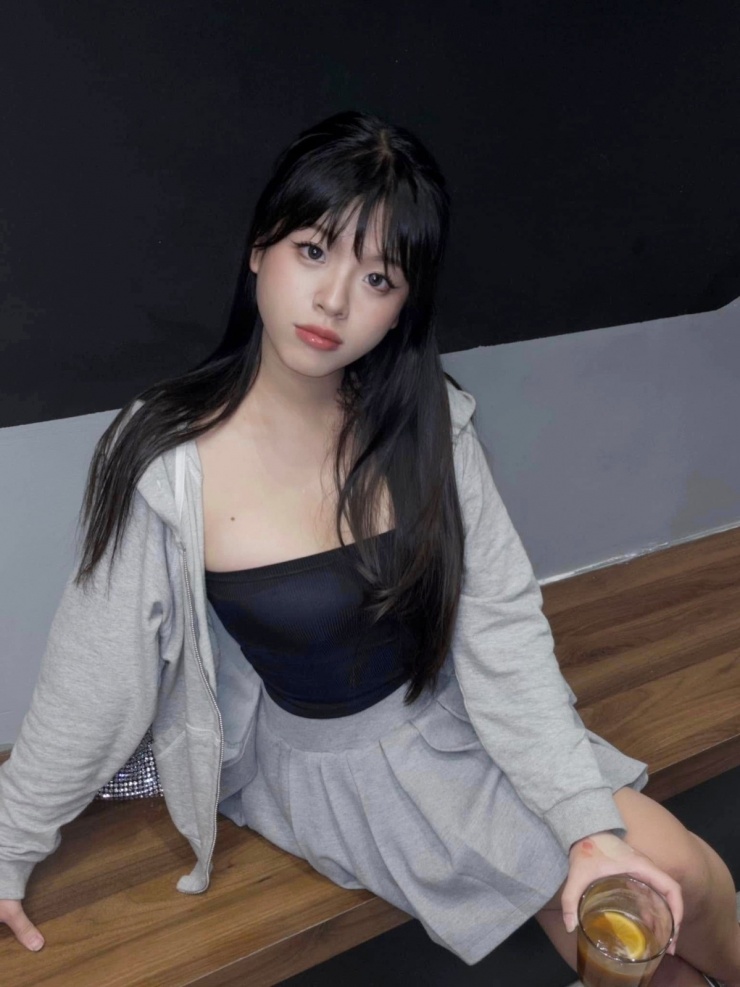 Phong cách nữ sinh được cô thể hiện với váy xếp ly ngắn, áo quây ngực và áo khoác hoodie.