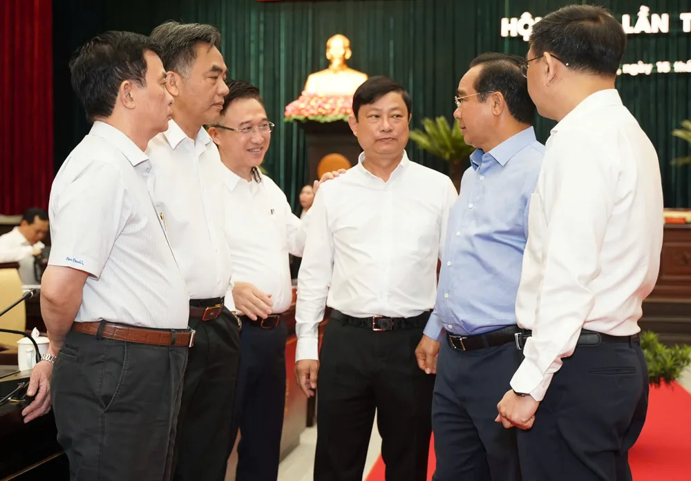 Lãnh đạo TP trao đổi bên lề hội nghị. Ảnh: THUẬN VĂN hop-ban-chp-hanh-tphcm (3).jpg
