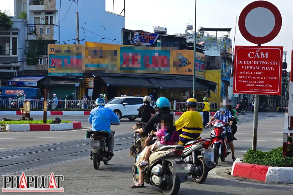 Người điều khiển xe máy băng ngang đường ray dù đã có biển báo cấm, tiềm ẩn nguy cơ tai nạn đặc biệt nghiêm trọng khi tàu hỏa di chuyển với tốc độ cao. Ảnh: PHẠM HẢI z7327713468767_8df4b105b83b8a08b1f11f347c550d65.jpg