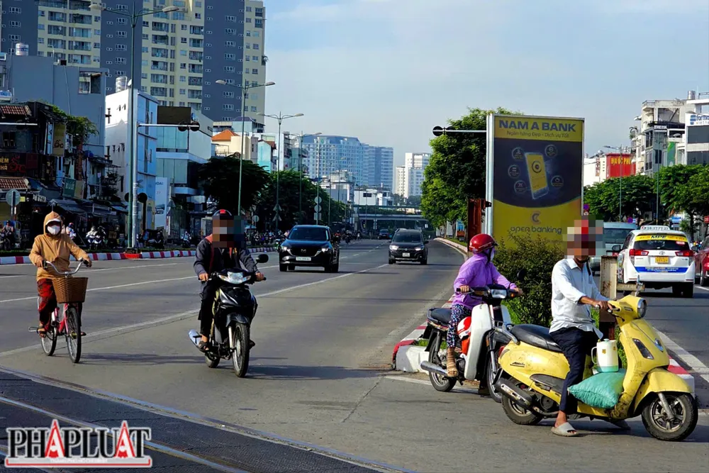 Người tham gia giao thông bất chấp nguy hiểm, lao nhanh qua đường ray trong khi hệ thống cảnh báo đã được lắp đặt đầy đủ. Ảnh: PHẠM HẢI z7327713480545_de3eb899bc84bda9397ce2c1fa9cc8b3.jpg