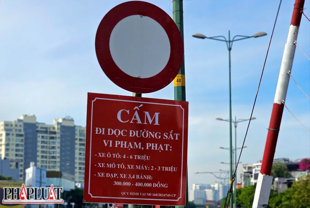 Biển báo cấm băng ngang qua đường ray, cảnh báo khu vực nguy hiểm, yêu cầu người tham gia giao thông tuyệt đối không vượt qua nhằm bảo đảm an toàn đường sắt và tính mạng con người. Tuy nhiên, nhiều người vẫn phất lờ biển cấm. Ảnh: PHẠM HẢI z7327713471590_979082dc307fe5c4d5dd9c5a0016a3d8.jpg