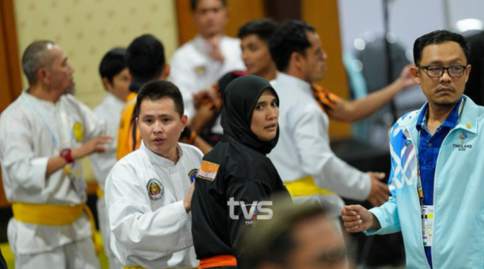 HLV Pencak Silat Malaysia, Siti Rahmah Mohamed Nasir, được hộ tống ra khỏi khu vực trọng tài. Ảnh: TVS