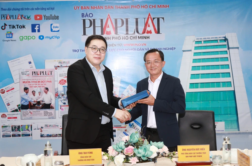 Ông Tao Feng, Tổng Biên tập báo Văn Hối Thượng Hải tặng món quà kỷ niệm cho ông Nguyễn Đức Hiển, Phó Tổng Biên tập thường trực báo Pháp Luật TP.HCM. Ảnh: NGUYỆT NHI bao-van-hoi-thuong-hai-8.jpg