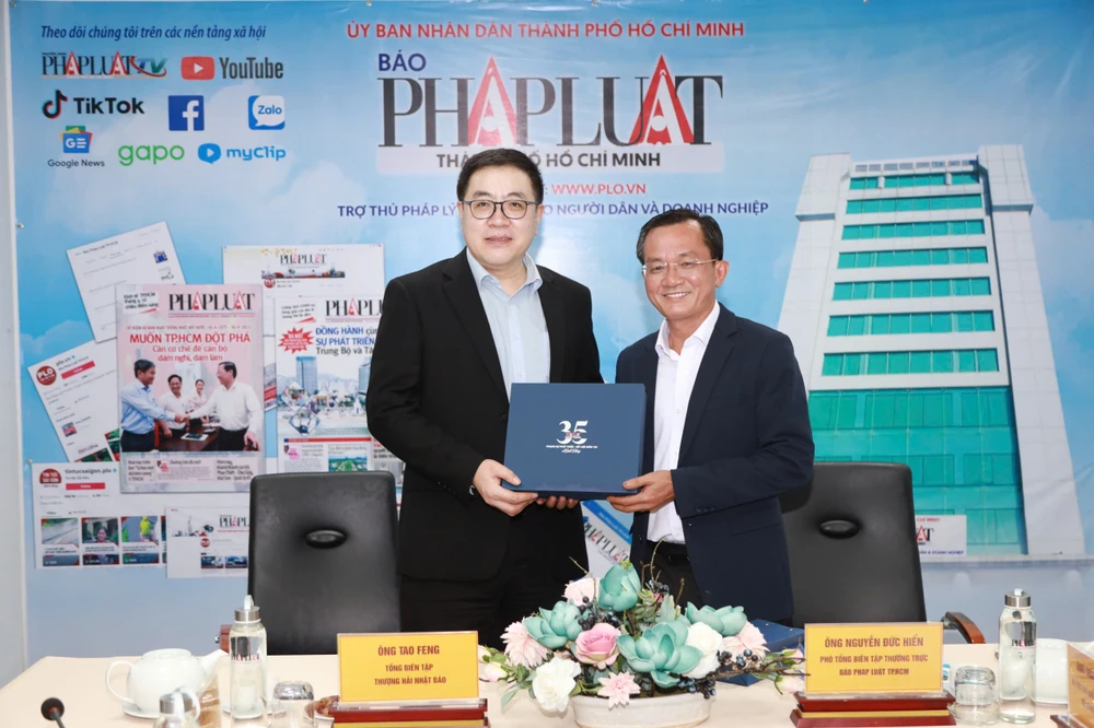 Phó Tổng Biên tập thường trực báo Pháp Luật TP.HCM Nguyễn Đức Hiển tặng món quà kỷ niệm cho ông Tao Feng, Tổng Biên tập báo Văn Hối Thượng Hải. Ảnh: NGUYỆT NHI bao-van-hoi-thuong-hai-2-7.jpg