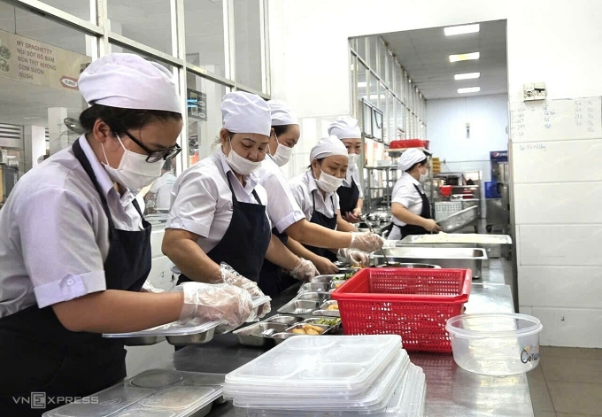 Các nhân viên bếp ăn phân suất ăn trưa cho học sinh tại trường THPT Trưng Vương, ngày 18/12. Ảnh: Lệ Nguyễn