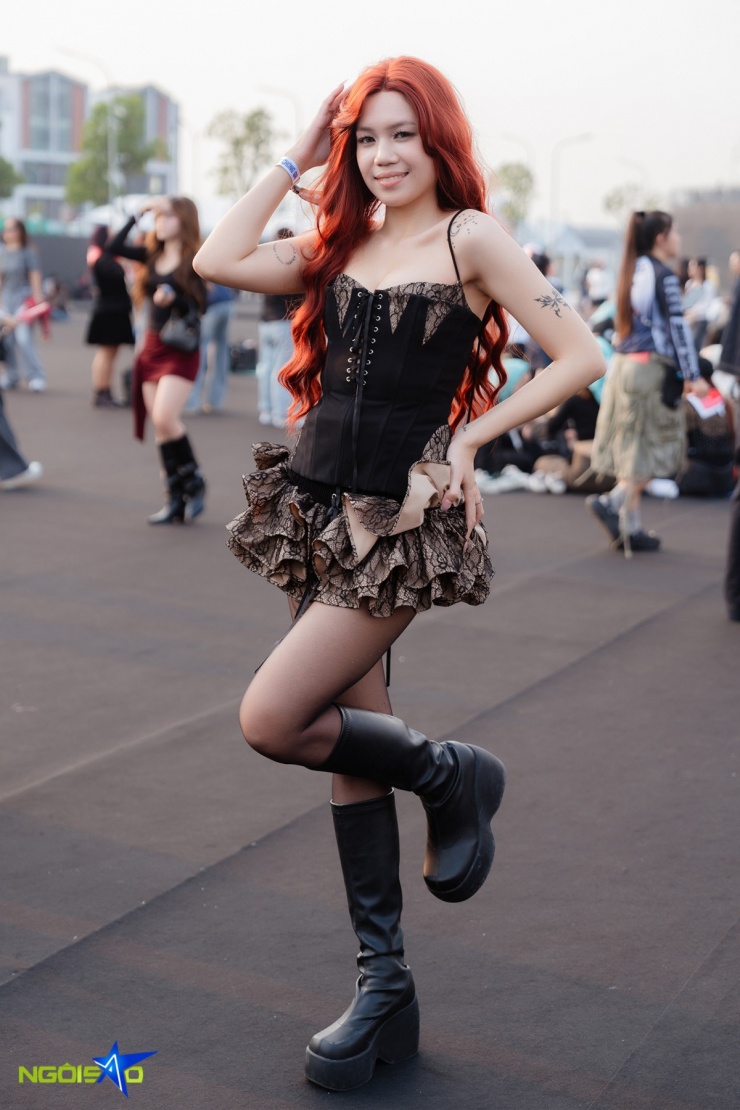 Quỳnh Nga theo đuổi phong cách gợi cảm, nổi loạn với corset ren đen ôm sát cơ thể, khoe đường cong. Cô kết hợp chân váy ngắn bèo tầng tạo độ bồng và chuyển động mềm mại, giúp tổng thể vừa quyến rũ vừa cá tính.