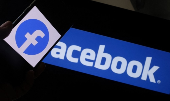 Hình minh họa logo Facebook trên điện thoại thông minh trước màn hình máy tính ở Los Angeles, Mỹ. Ảnh: AFP