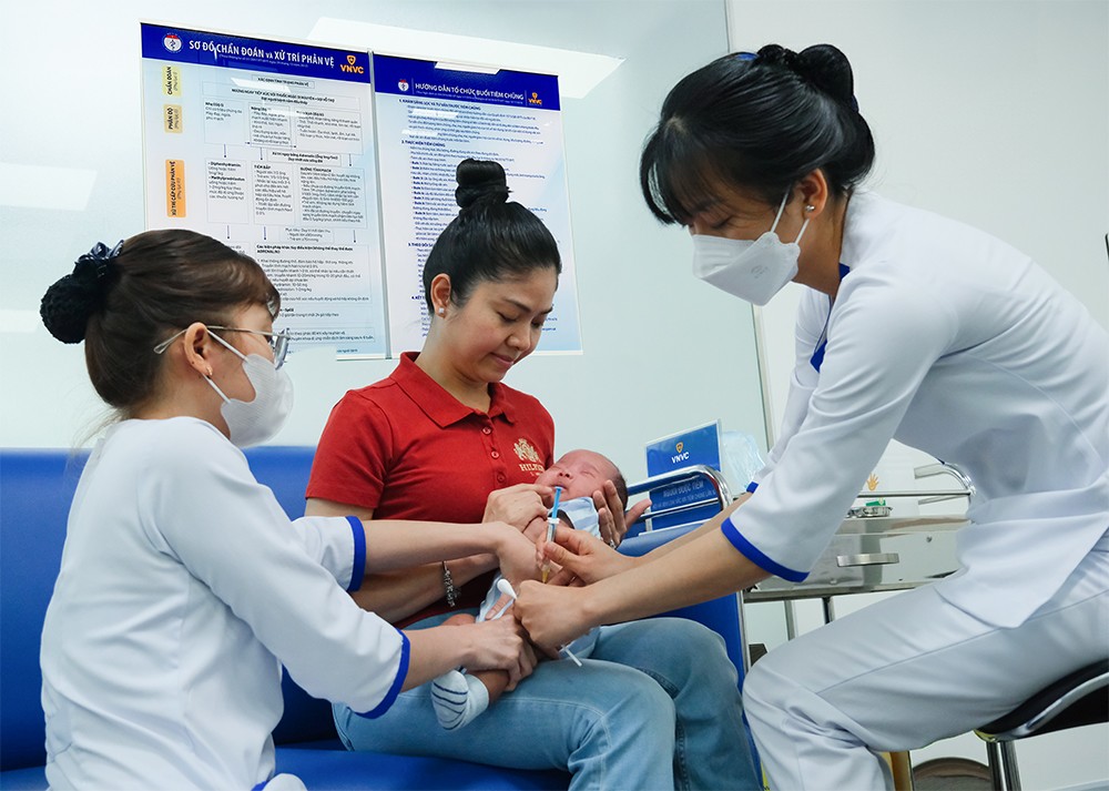 Chị Vạn Chí Linh cho con trai Gia Hưng đến VNVC Lê Đại Hành (TP HCM) tiêm kháng thể đơn dòng phòng RSV, sáng ngày 23/12. Ảnh: Diễm Chinh