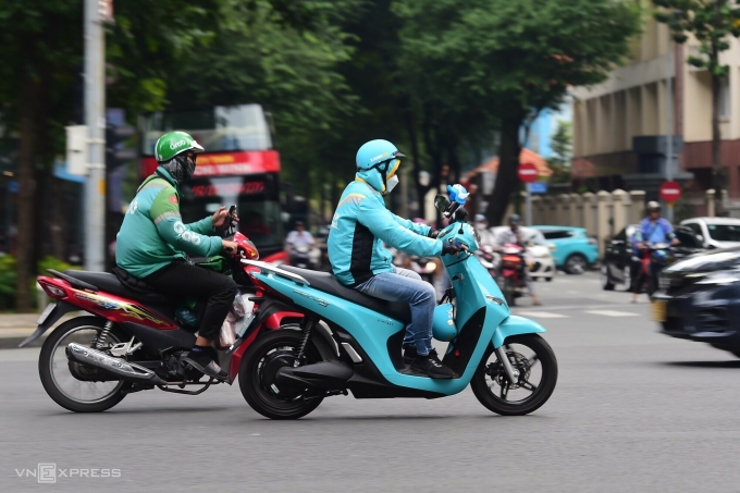 Tài xế hai hãng xe sử dụng xe xăng và xe điện chạy trên đường trung tâm TP HCM. Ảnh: Thanh Tùng