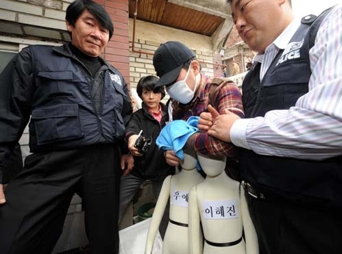 Jeong Seong-hyeon bị cảnh sát dẫn đi thực nghiệm hiện trường, tháng 3/2008. Ảnh: Yonhap