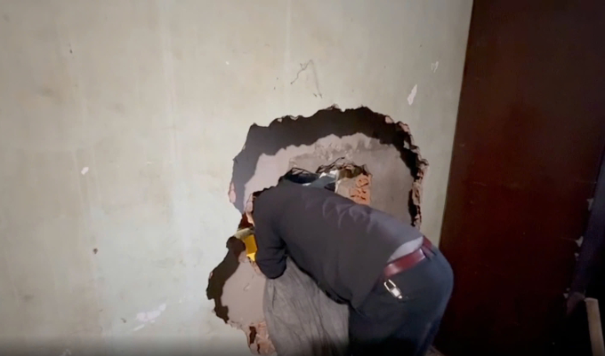 Bức tường giữa 2 căn nhà được lực lượng chức năng phá vỡ để tiếp cận hiện trường cứu nạn. Ảnh: Ngọc Oanh