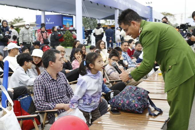 Thiếu tá Phạm Đăng Quý đặt câu hỏi cho trẻ tham gia workshop Thoát hiểm - thoát nạn trên xe. Ảnh: Lương Dũng