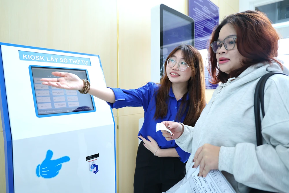 Người dân được hỗ trợ lấy số thứ tự ở ngoài cửa. Ảnh: LÊ THOA trung-tam-phuc-vu-hanh-chinh-cong-tphcm-3.JPG