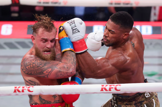 Anthony Joshua (phải) ra đòn trong trận gặp Jake Paul tại Miami, Mỹ, ngày 20/12/2025. Ảnh: Reuters
