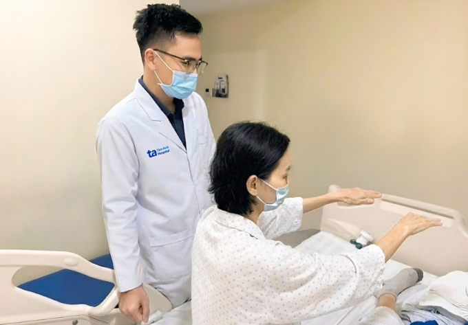 Bác sĩ Giáp đang kiểm tra vận động sau điều trị cho chị Thu. Ảnh: Bệnh viện Đa khoa Tâm Anh