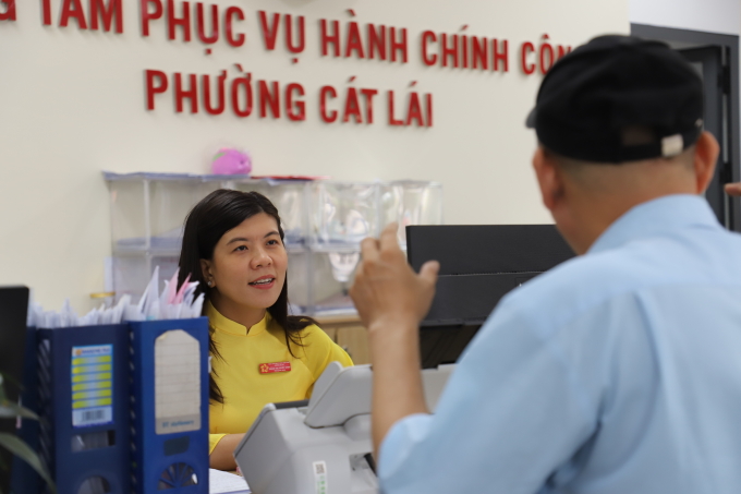 Cán bộ Trung tâm phục vụ hành chính công phường Cát Lái trả lời thắc mắc của người dân khi đến làm thủ tục, ngày 17/9. Ảnh: Lê Tuyết