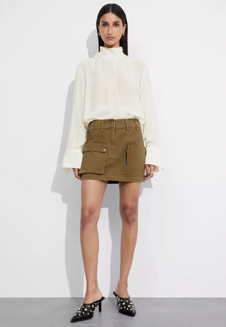 Chân váy cargo là một trong những item thuộc phong cách Y2K, chúng từng rất phổ biến vào đầu những năm 2000, và đang trên đà quay trở lại vòng xoay xu hướng. Các cô gái thường phối áo crop top hoặc áo thun in họa tiết lính cùng váy cargo, nhưng cách kết hợp quen thuộc này sẽ trở nên nhàm chán trên bản đồ thời trang.