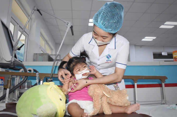 Bé Linh được điều dưỡng Lê Thủy Tiên chăm sóc tại giường bệnh. Ảnh: Văn Linh