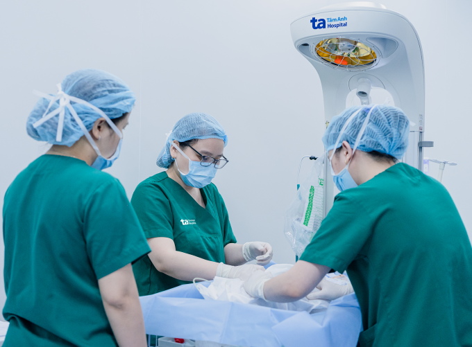 Bác sĩ Lan (giữa) cùng êkíp Sơ sinh kiểm tra sức khỏe của bé ngay sau sinh, trước khi da kề da với mẹ. Ảnh: Trung Vũ