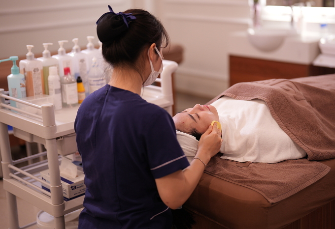 Kỹ thuật viên khoa Thẩm mỹ đang chăm sóc da cho một phụ nữ. Ảnh: Bệnh viện cung cấp