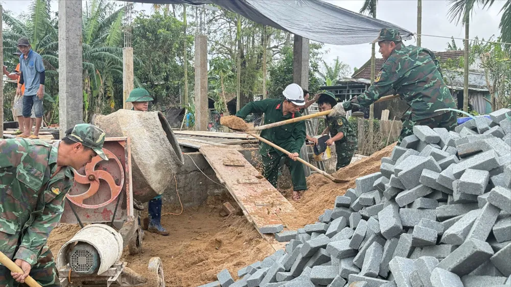 Các lực lượng tham gia xây nhà cho người dân vùng lũ. Ảnh: T.Q Quang Trung 1.jpg