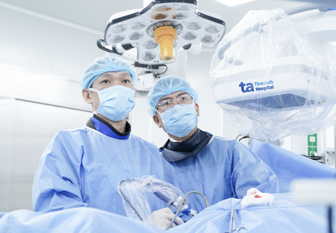 Cùng lúc mắc hai loại sỏi tiết niệu 1 Bác sĩ Cương (trái) đang tán sỏi niệu quản và sỏi thận cho ông Tư. Ảnh: Bệnh viện Đa khoa Tâm Anh