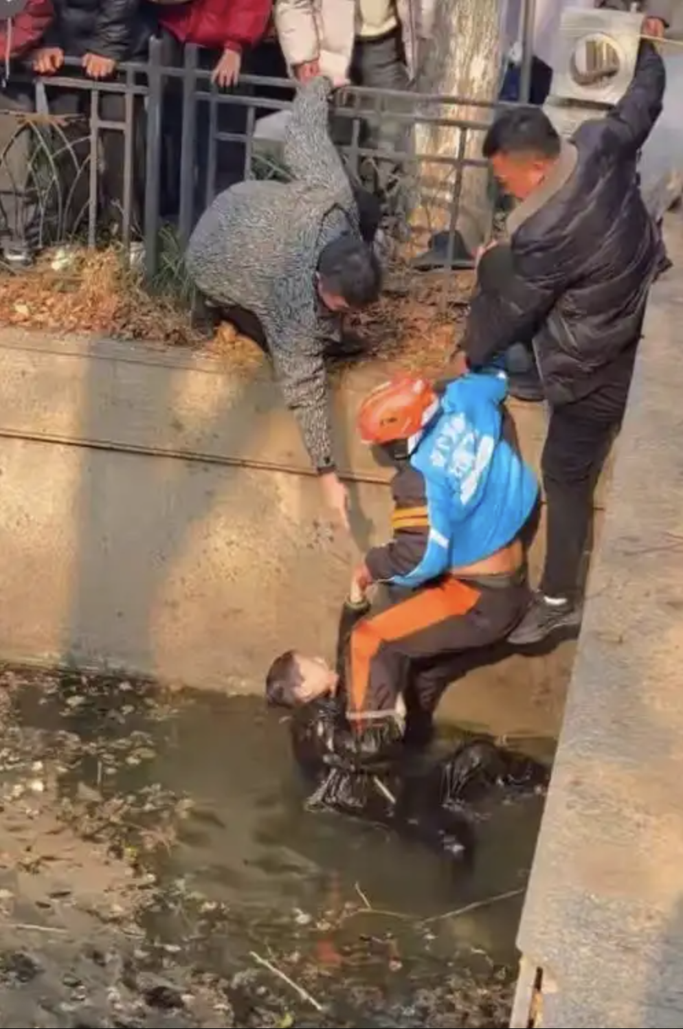 Đang giao đồ ăn, shipper phát hiện 1 cậu bé mặc đồ đen đang trôi nổi dưới kênh nước đục ngầu- Ảnh 1.