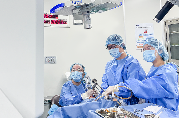 [GS Chung Thủy (ngồi) đang phẫu thuật laser C02 loại bỏ khối u ung thư cho ông Khâu. Ảnh: Bệnh viện Đa khoa Tâm Anh