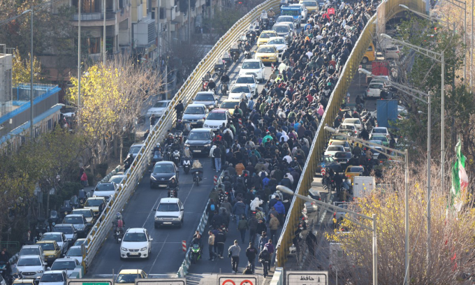 Người biểu tình di chuyển trên cầu tại thủ đô Tehran của Iran hôm 29/12. Ảnh: AFP