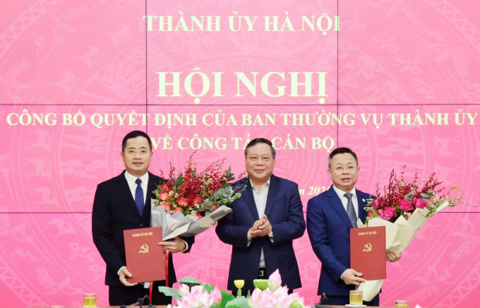Phó Bí thư Thường trực Thành ủy Hà Nội Nguyễn Văn Phong trao quyết định cho ông Trần Thanh Hà (bên phải) và ông Nguyễn Thành Long (bên trái), sáng 26/12. Ảnh: Viết Thành