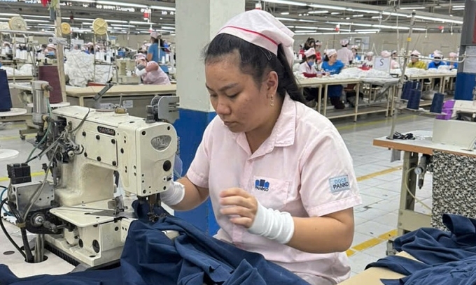 Nữ công nhân Cẩm Thi cùng đồng nghiệp hoàn tất đơn hàng cuối cùng cho nhà máy. Ảnh: An Phương