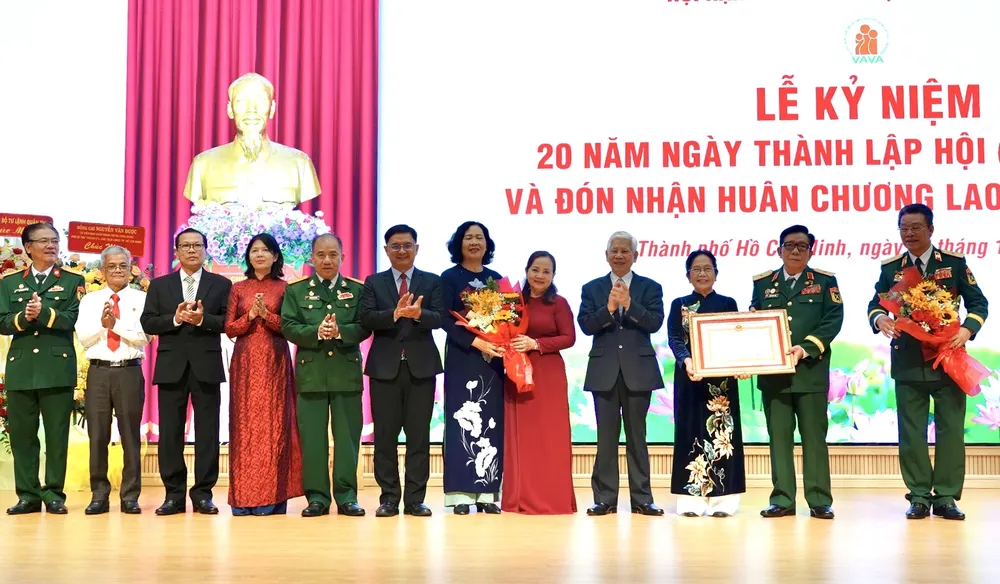 Nguyên Ủy viên Bộ Chính trị, nguyên Chủ tịch nước Nguyễn Minh Triết (thứ tư, từ phải qua); Phó Chủ tịch UBND TP.HCM Nguyễn Mạnh Cường (thứ sáu, từ trái qua), trao Huân chương Lao động hạng Ba cho tập thể Hội Nạn nhân chất độc da cam/dioxin TP.HCM. Ảnh: HẢI NHI Huân chương Lao động hạng Ba (6).jpg