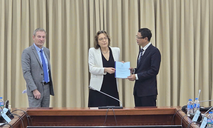 Thứ trưởng Khoa học và Công nghệ Lê Xuân Định nhận bản dự thảo báo cáo INIR sơ bộ từ bà Aline Des Cloizeaux, trưởng phòng Năng lượng hạt nhân thuộc Ban Năng lượng hạt nhân của IAEA. Ảnh: TTTT