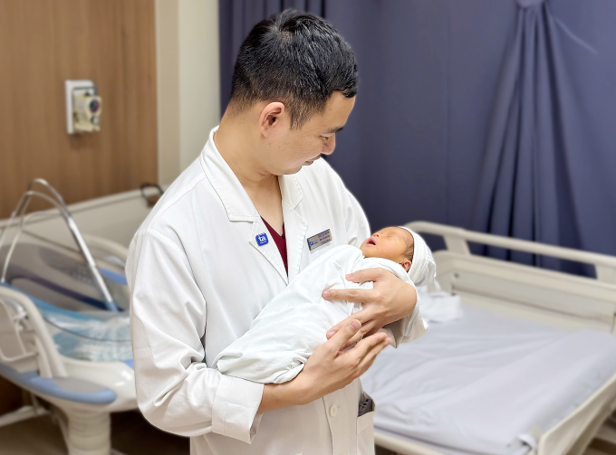 Bác sĩ Tuấn Anh bế con gái của chị Lê mới chào đời. Ảnh: Bệnh viện Đa khoa Tâm Anh