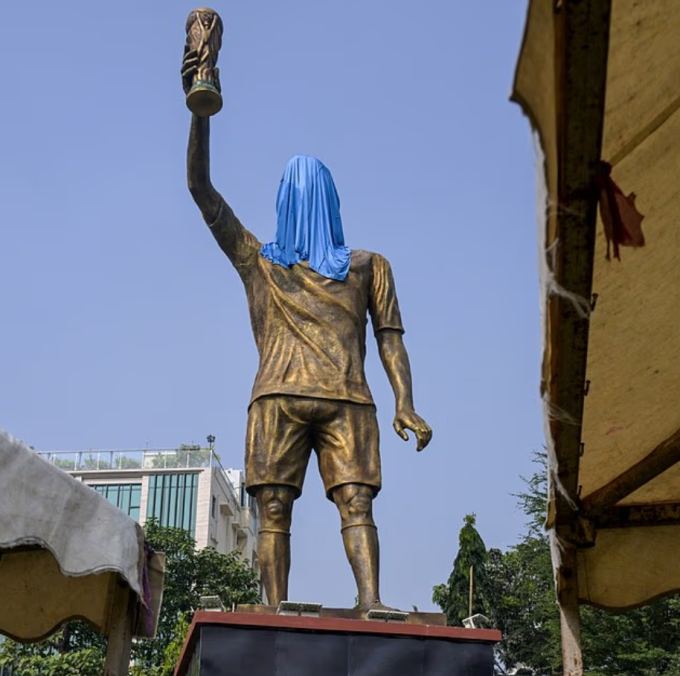 Nhằm giữ bí mật trước lễ ra mắt, nhà chức trách đã phủ một tấm màn che lên phần đầu của tượng Messi. Ảnh: AFP