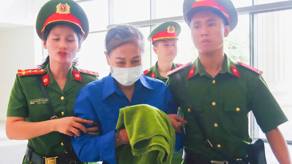 Cảnh sát dẫn giải bị cáo Hoàng Thị Thúy Lan đến phiên tòa sơ thẩm. Hoang-Thuy-Lan.jpg