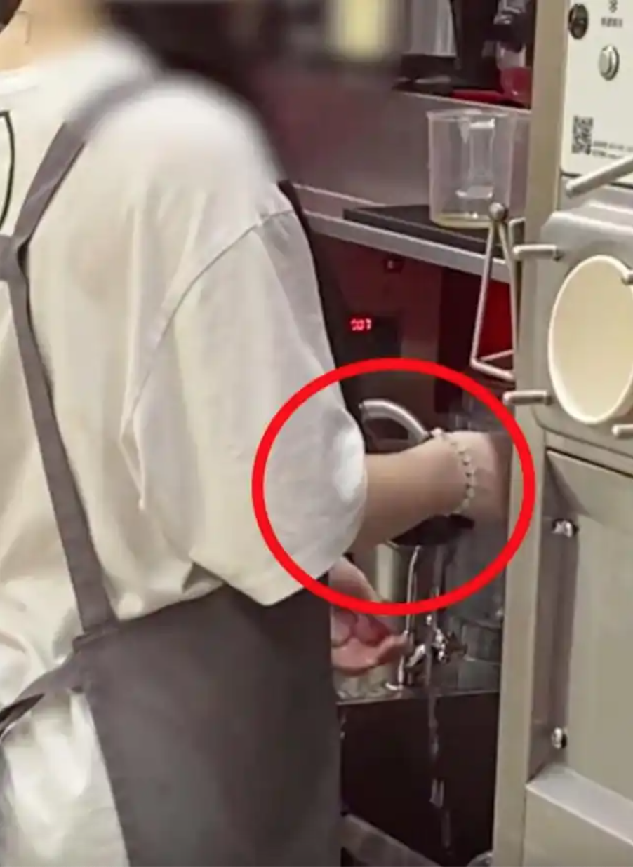 Nhân viên quán trà sữa gội đầu ngay tại bồn rửa ở quầy pha chế, trong bồn vẫn còn dụng cụ dùng để ép trái cây- Ảnh 1.