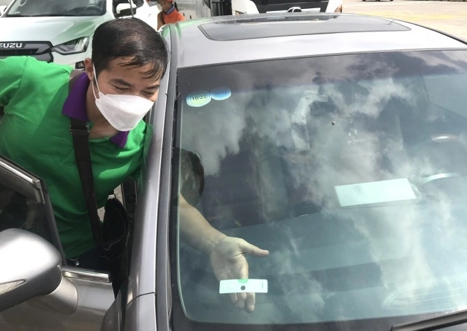 Dán thẻ VETC cho phương tiện tham gia giao thông. Ảnh: Anh Duy