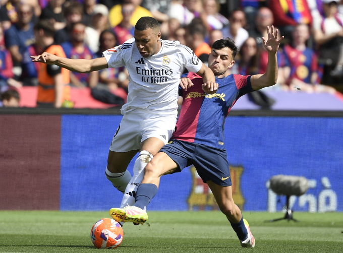 Mbappe đi bóng trước sự truy cản của Pedri trong trận Real thua Barca 3-4 ở vòng 35 La Liga ngày 11/5/2025. Ảnh: AFP