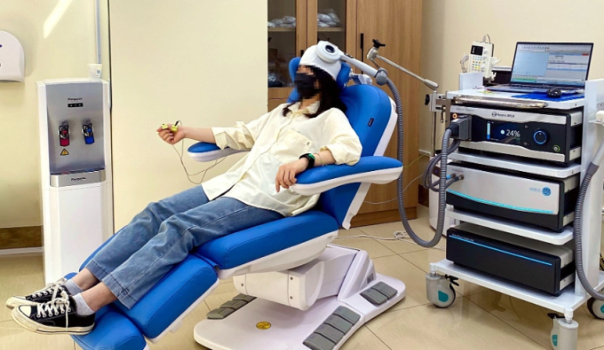 Người bệnh mất ngủ điều trị với máy kích thích từ trường xuyên sọ. Ảnh: Trung Vũ